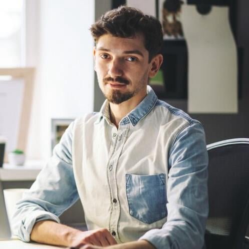 Man checking the Elite Singles app on his phone and laptop at home